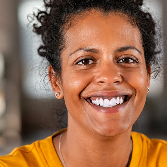 Woman with a bright smile wearing a yellow shirt