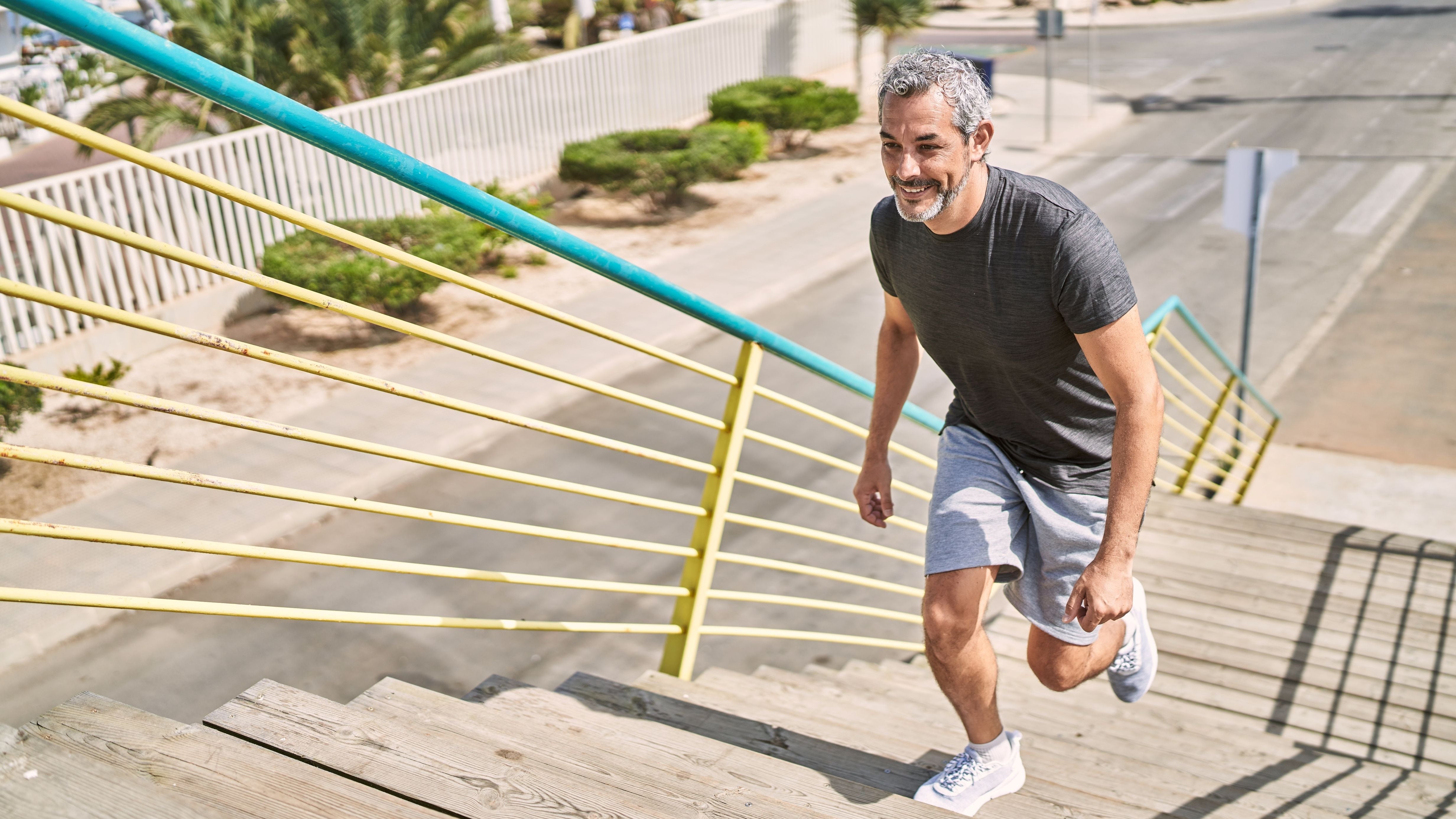 Man running up a set of stairs on a sunny day