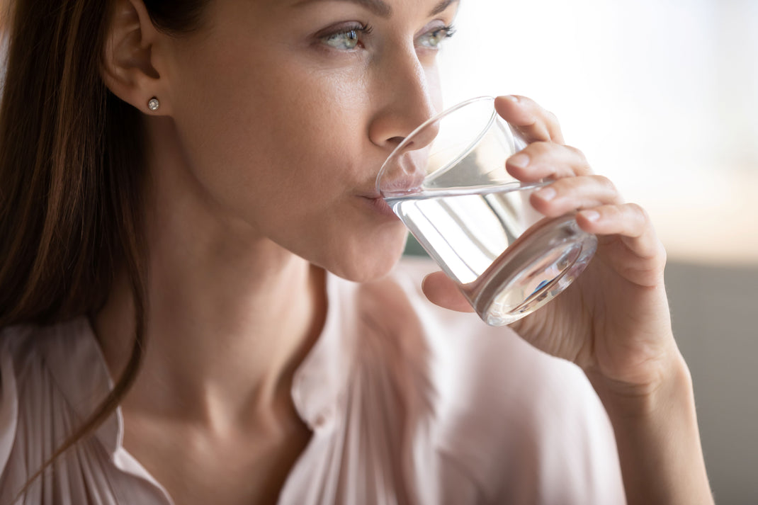 Woman drinking water from a glass indoors