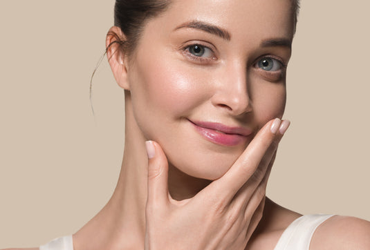 Woman touching her face with a beige background
