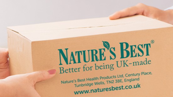 Cardboard box with 'Nature's Best' branding held by hands against a gray background