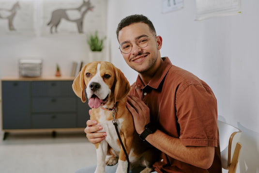 Man holding a dog in a living room setting